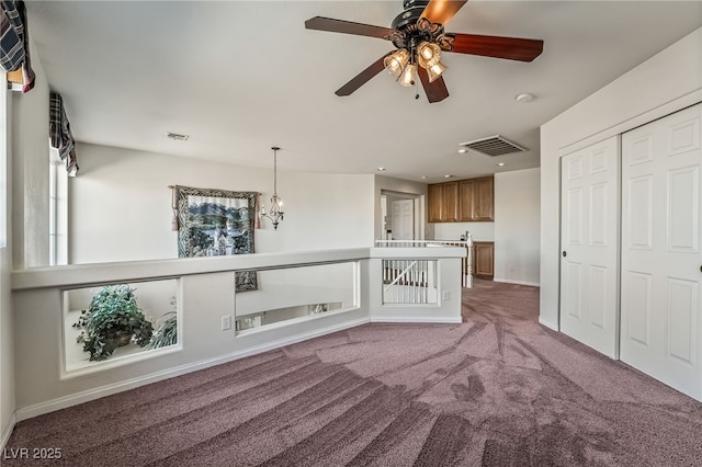 unfurnished living room featuring ceiling fan with notable chandelier, baseboards, carpet flooring, visible vents, and recessed lighting
