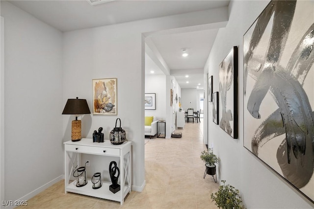 corridor featuring light tile patterned floors, baseboards, and recessed lighting