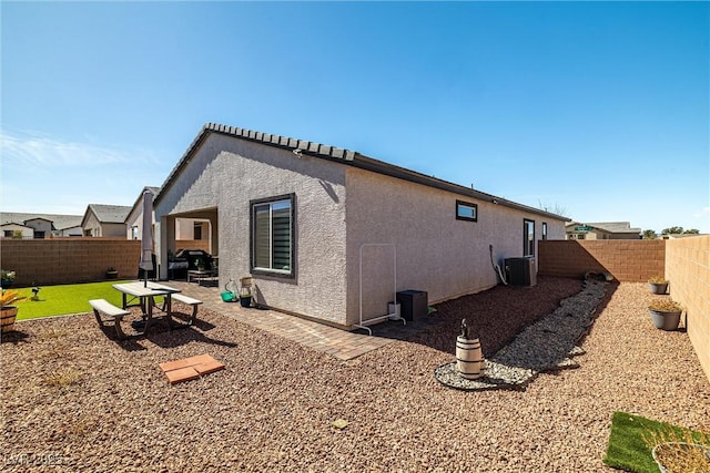 view of home's exterior with stucco siding, a patio, central AC unit, and a fenced backyard