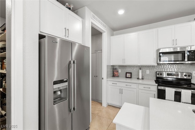 kitchen with white cabinetry, light countertops, tasteful backsplash, and stainless steel appliances