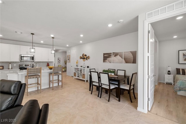 dining room featuring light tile patterned floors, visible vents, recessed lighting, and baseboards