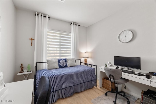 bedroom featuring baseboards and wood finished floors