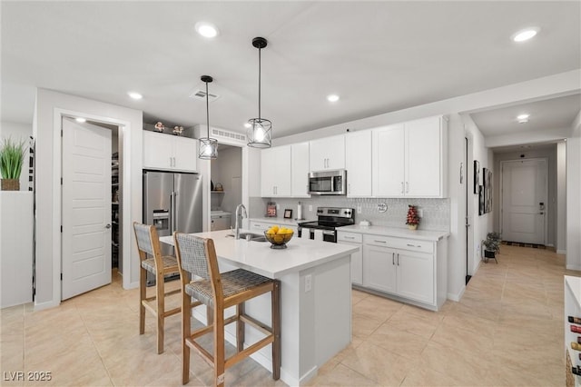 kitchen featuring visible vents, a kitchen breakfast bar, tasteful backsplash, appliances with stainless steel finishes, and light countertops