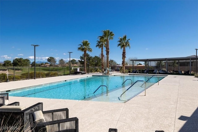 community pool with a patio area and fence