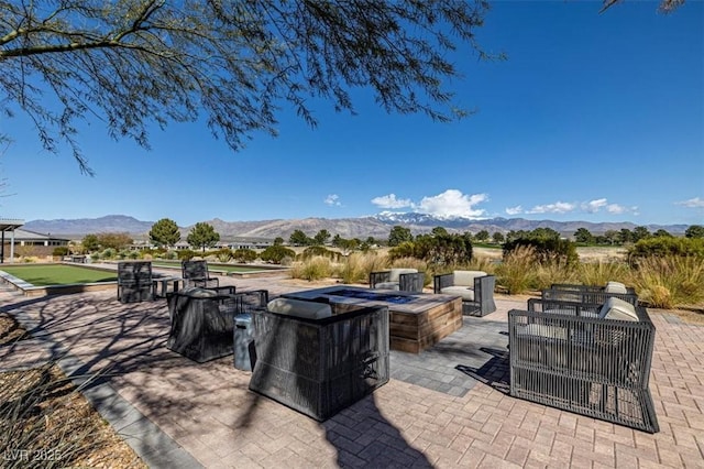 view of patio with a mountain view and an outdoor fire pit