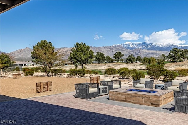 view of patio / terrace with a mountain view and an outdoor fire pit