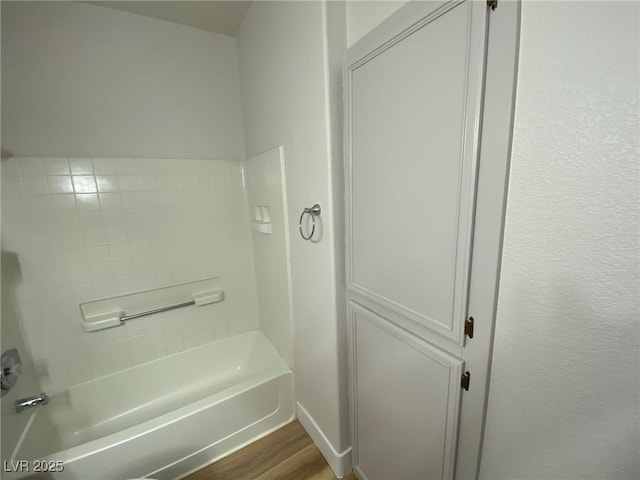 full bath with washtub / shower combination and wood finished floors