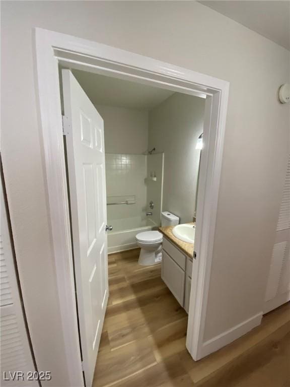 bathroom with shower / washtub combination, vanity, toilet, and wood finished floors