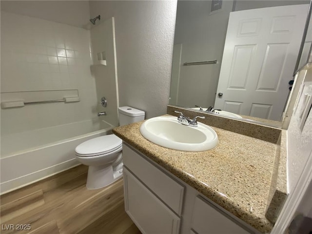 bathroom with visible vents, toilet, tub / shower combination, vanity, and wood finished floors