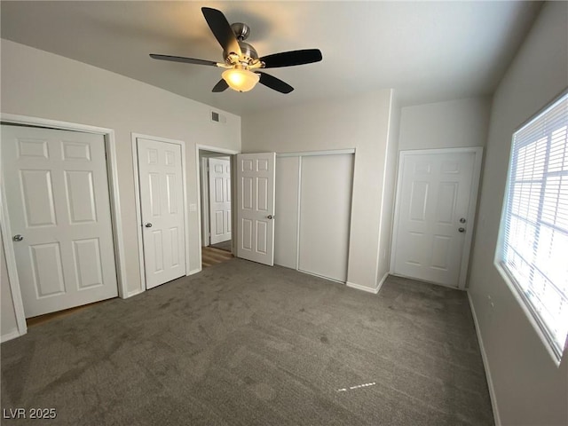 unfurnished bedroom with ceiling fan, carpet flooring, visible vents, and baseboards