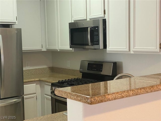 kitchen featuring white cabinetry, appliances with stainless steel finishes, and light stone counters