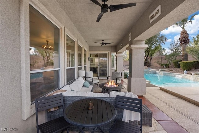 view of patio with ceiling fan, an outdoor fire pit, outdoor dining space, and an outdoor pool