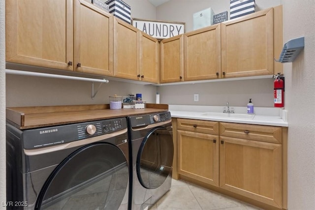 laundry area with light tile patterned flooring, a sink, cabinet space, and washer and dryer