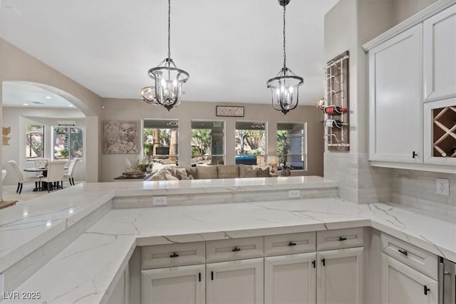 kitchen featuring a chandelier, hanging light fixtures, open floor plan, and white cabinets