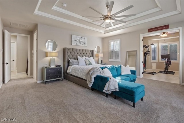 carpeted bedroom with baseboards, visible vents, a raised ceiling, a ceiling fan, and crown molding