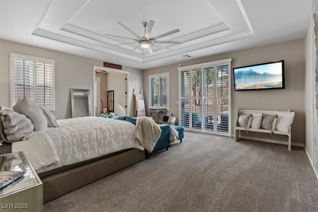 bedroom featuring access to outside, a raised ceiling, and carpet