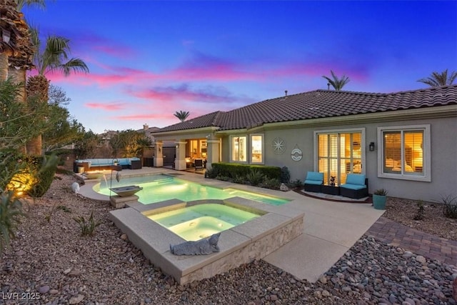 pool at dusk with an outdoor pool, outdoor lounge area, a patio, and an in ground hot tub