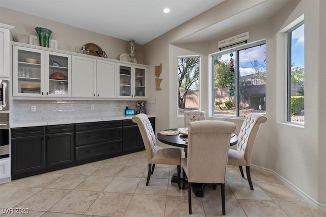 dining area with light tile patterned floors, baseboards, and recessed lighting