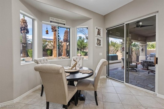 dining room featuring baseboards, a ceiling fan, and light tile patterned flooring