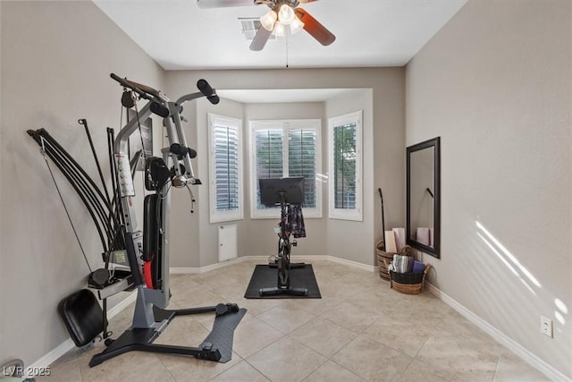 exercise area with baseboards and light tile patterned floors