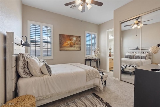 carpeted bedroom featuring ceiling fan, multiple windows, visible vents, and connected bathroom