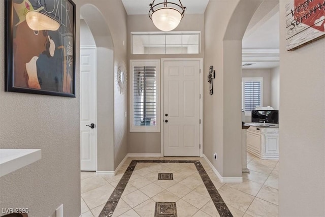 foyer with baseboards and arched walkways