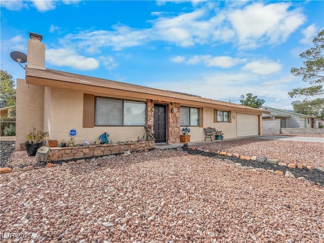 ranch-style house featuring stucco siding, driveway, a chimney, and a garage