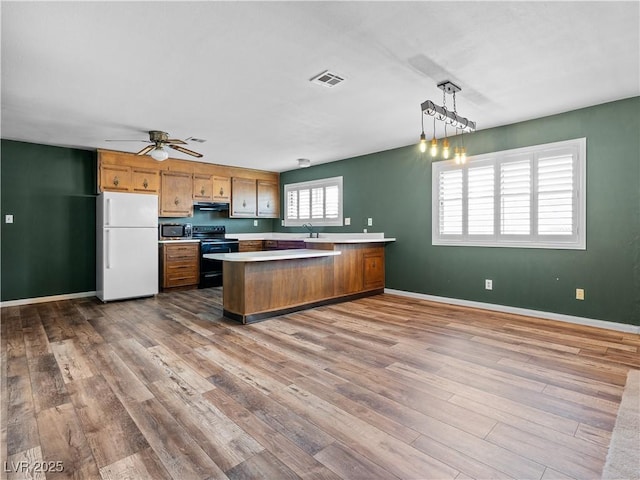 kitchen with visible vents, black electric range oven, dark wood-style floors, freestanding refrigerator, and light countertops