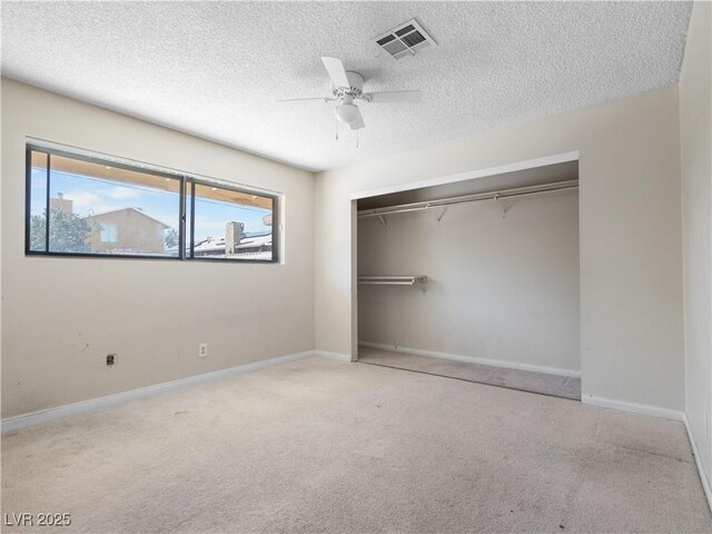 unfurnished bedroom featuring baseboards, visible vents, ceiling fan, a closet, and carpet flooring