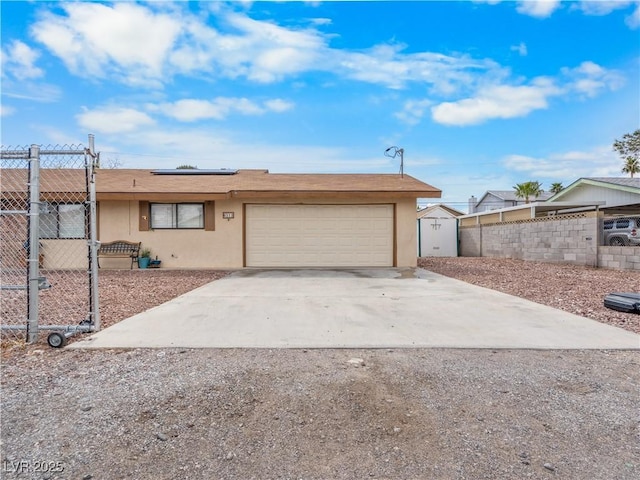 ranch-style home featuring fence, driveway, an attached garage, stucco siding, and roof mounted solar panels