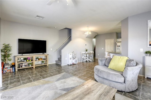 living room featuring a ceiling fan, visible vents, stairway, and baseboards