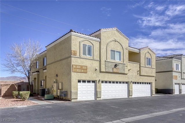 view of property with central air condition unit and a garage