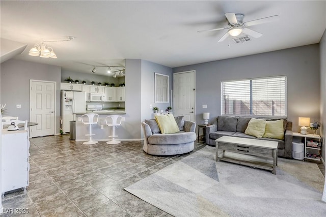 living room featuring visible vents, track lighting, and ceiling fan with notable chandelier