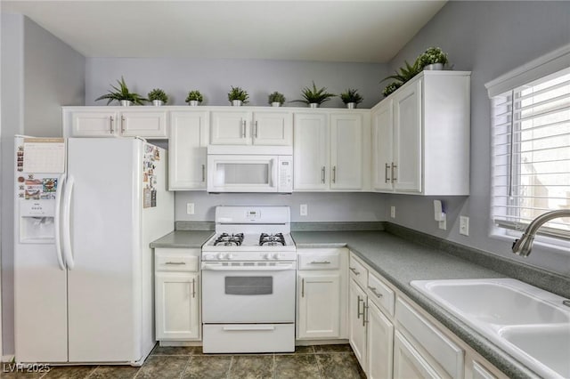 kitchen featuring white appliances, plenty of natural light, white cabinetry, and a sink