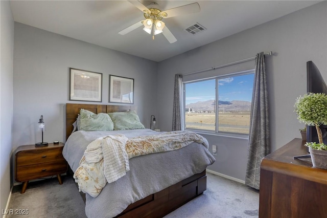 carpeted bedroom with a ceiling fan, visible vents, and baseboards