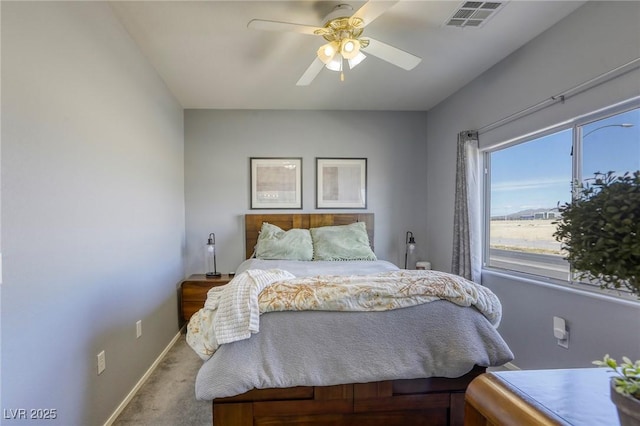 carpeted bedroom with a ceiling fan, visible vents, and baseboards