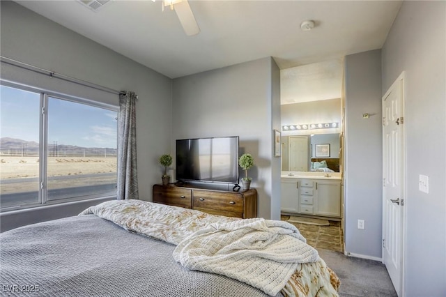 bedroom with ceiling fan, baseboards, carpet flooring, and ensuite bathroom