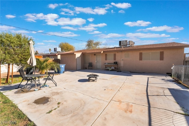 back of house featuring a fire pit, a patio, fence, and stucco siding