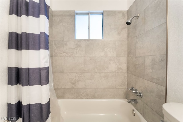 bathroom with toilet and shower / bath combo with shower curtain