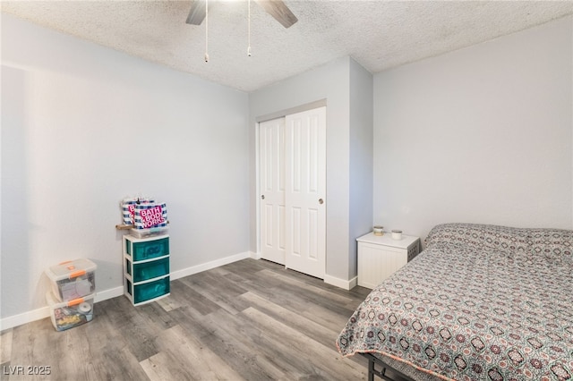 bedroom with a textured ceiling, ceiling fan, wood finished floors, baseboards, and a closet