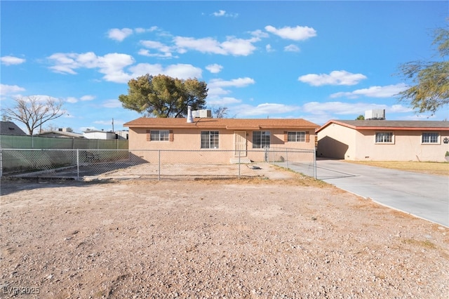 view of front of property featuring central AC unit, a fenced front yard, and stucco siding