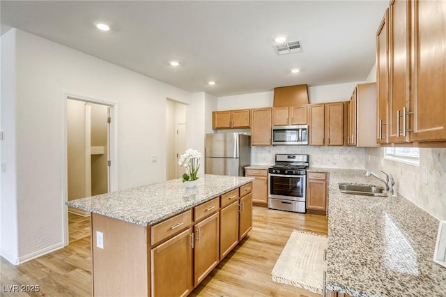 kitchen featuring stainless steel appliances, light wood-type flooring, visible vents, and a sink