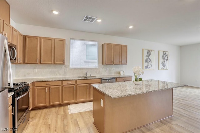 kitchen with light wood finished floors, visible vents, a sink, stainless steel appliances, and backsplash