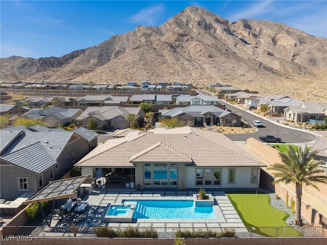 back of property featuring a patio, a fenced backyard, a mountain view, a tile roof, and a fenced in pool