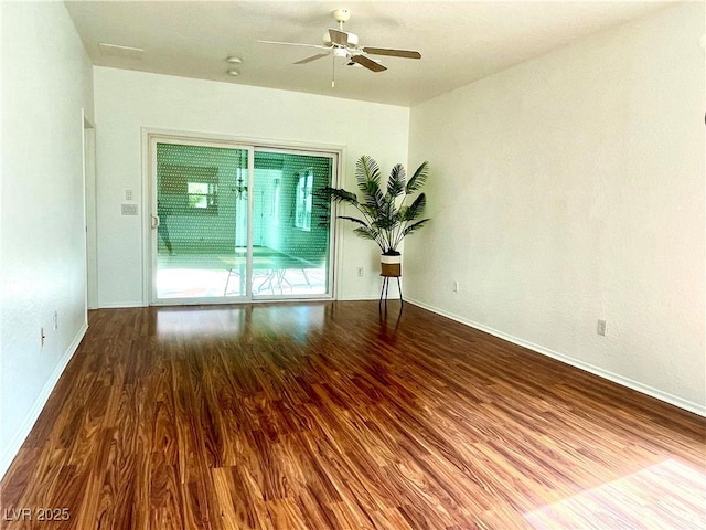 unfurnished room featuring ceiling fan, baseboards, and wood finished floors