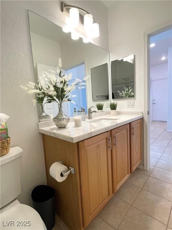 bathroom with tile patterned floors, toilet, a chandelier, and vanity