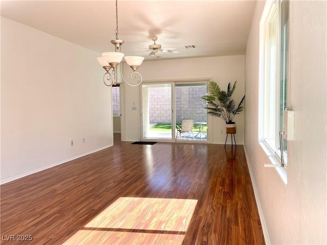 unfurnished room with a chandelier, visible vents, baseboards, and wood finished floors