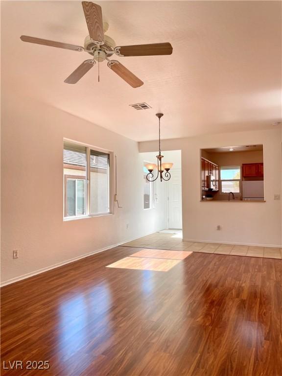 unfurnished living room featuring a wealth of natural light, visible vents, and light wood finished floors