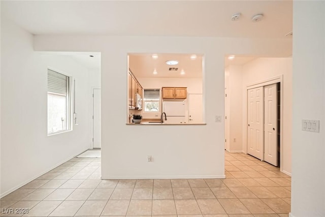 empty room featuring plenty of natural light, baseboards, and light tile patterned floors