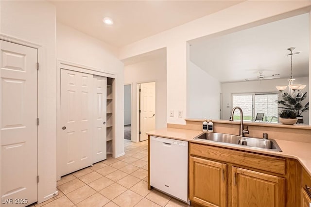 kitchen featuring light tile patterned floors, white dishwasher, a sink, light countertops, and a chandelier